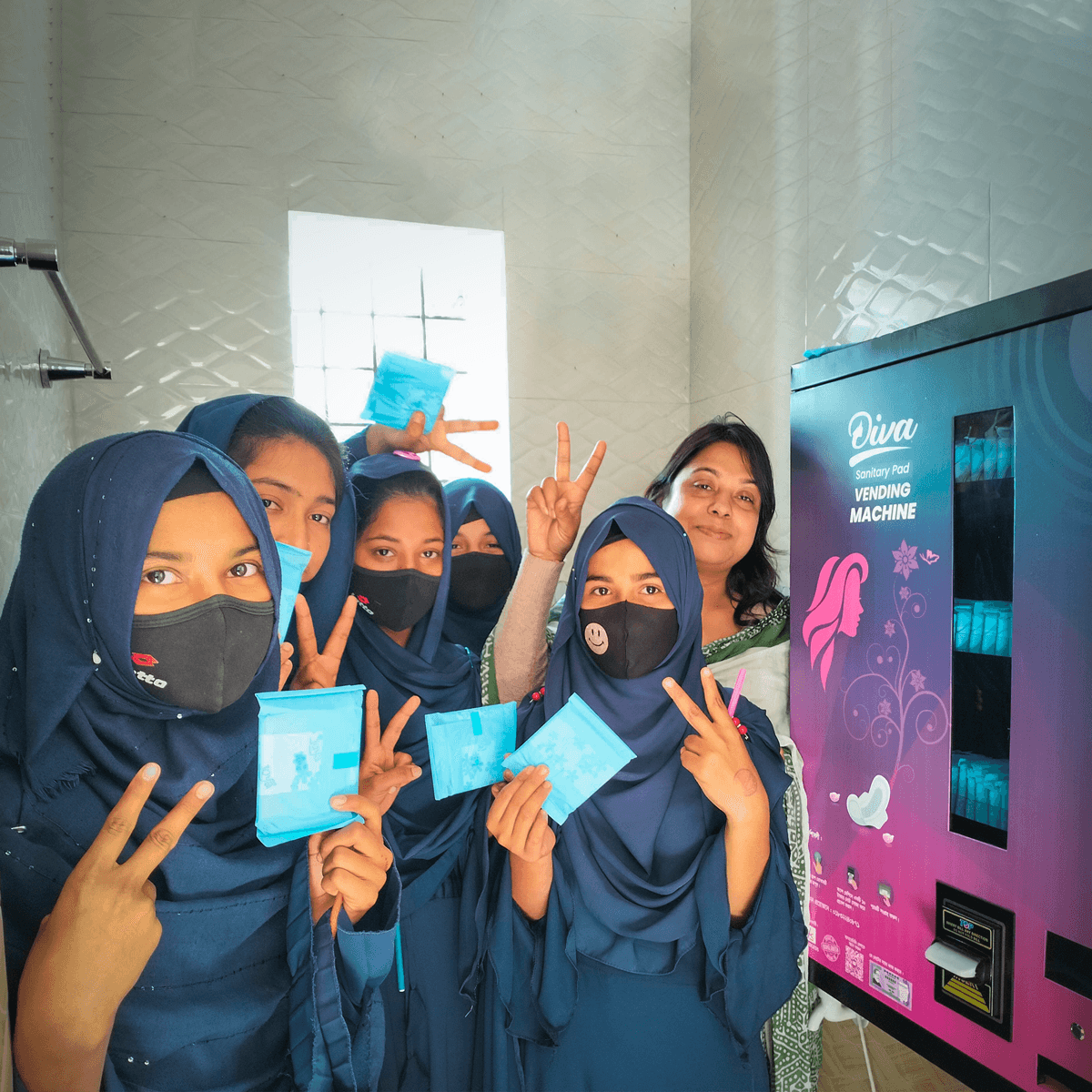 Schoolgirls using sanitary pad vending machine 